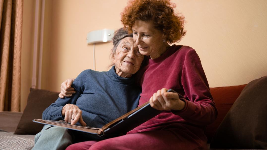 Family Caregiving daughter on hugging mom on couch
