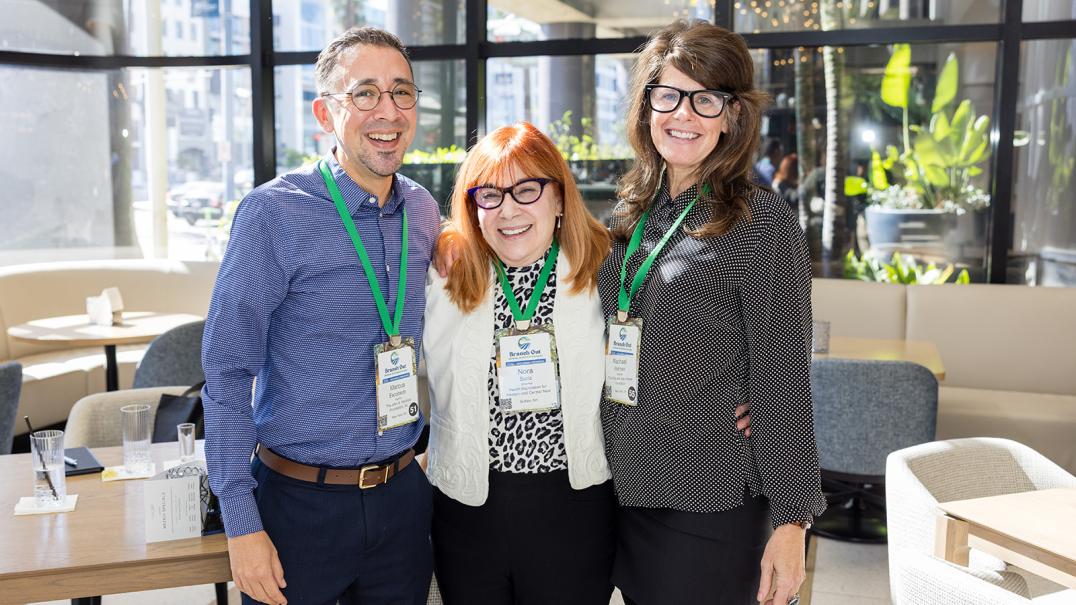 two white women and one man in a sunny room