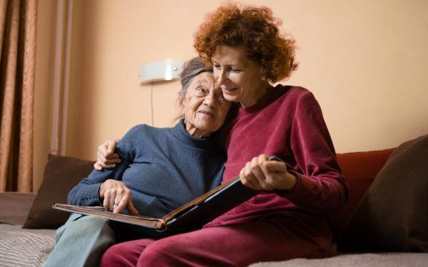 Family Caregiving daughter on hugging mom on couch