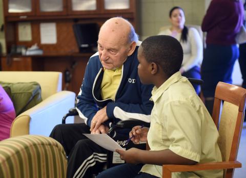 Child in yellow shirt and older man sitting