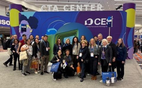 group of people standing in front of a CES banner