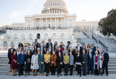 large group of people standing in front of the capital building